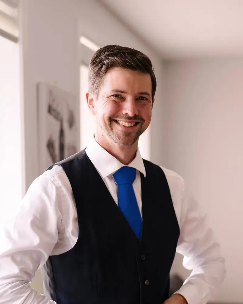 Mark Lewis, mechatronics engineer and founder of Neutrino, smiling in a navy vest and blue tie